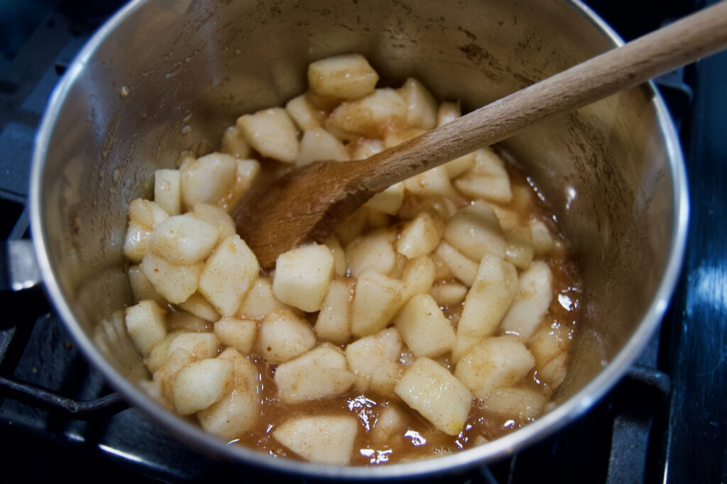 Cooking quick pear butter on the stove top until pear chunks soften.