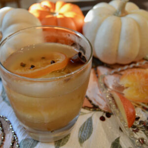 Garnishing this apple cider cocktail with a candied orange slices with cloves inserted into slice for additional flavor and visual appeal.