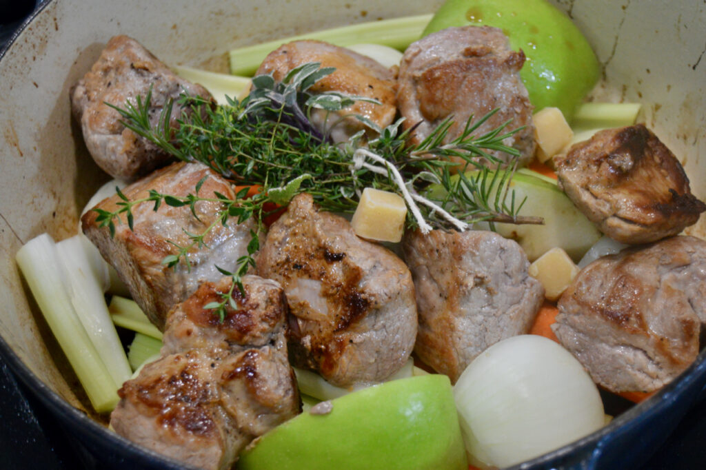 Searing pork tenderloin on a bed of carrots, celery, onions, and apples creates a sweet and savory Braised Spiced Cider Pork Tenderloin.