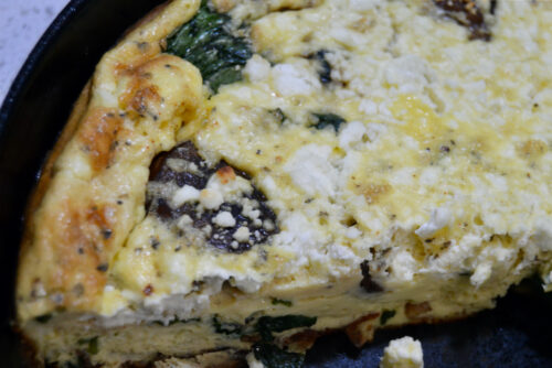 Layers of mushrooms, spinach, bacon and goat cheese crumbles make up this high protein frittata.