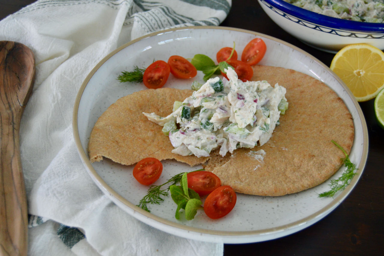 Serve tzatziki chicken salad with pita, cherry tomatoes and fresh herbs.