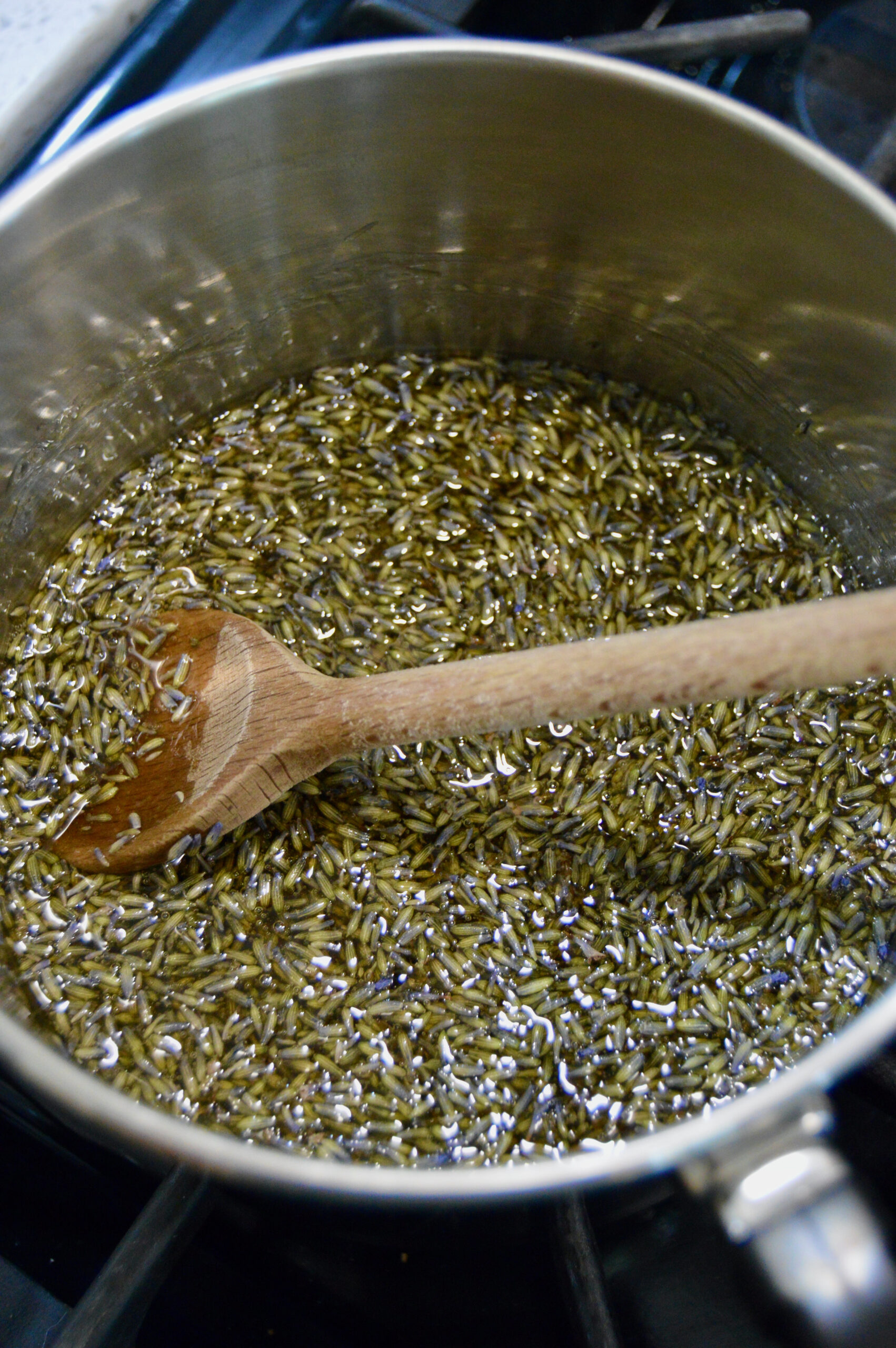 Dried lavender flowers in honey heated to infuse on stove