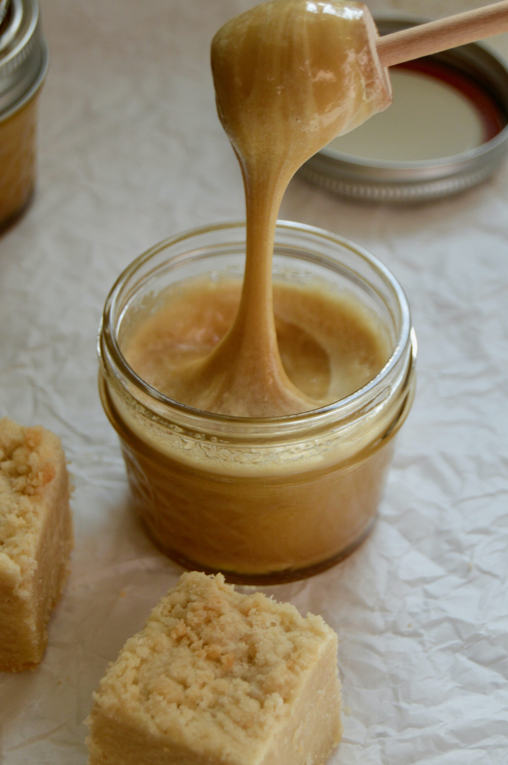 Creamy honey that is drizzled on shortbread bars with honey stirrer